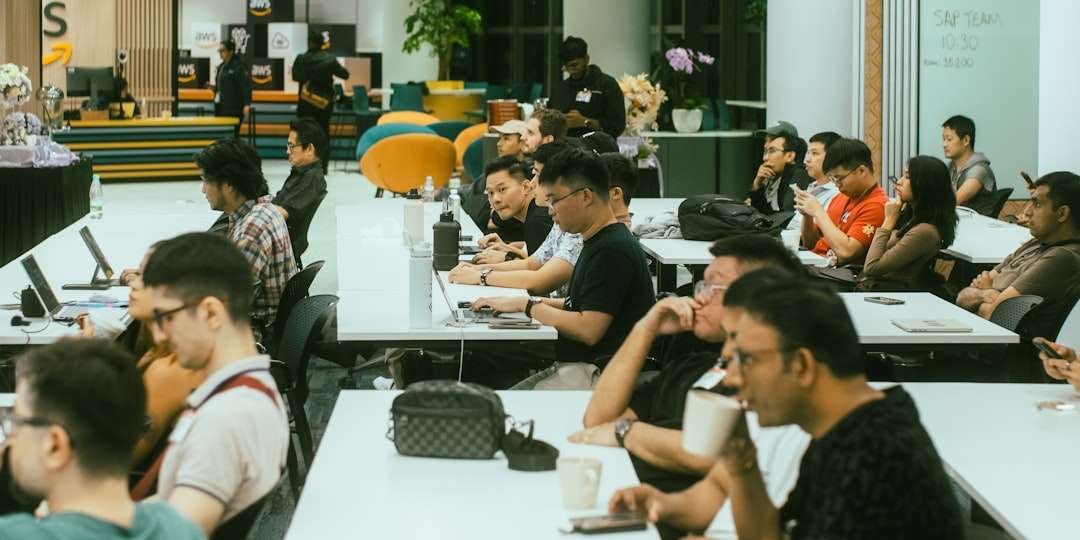 A group of people sitting at tables with laptops tech team, software debugging, data recovery