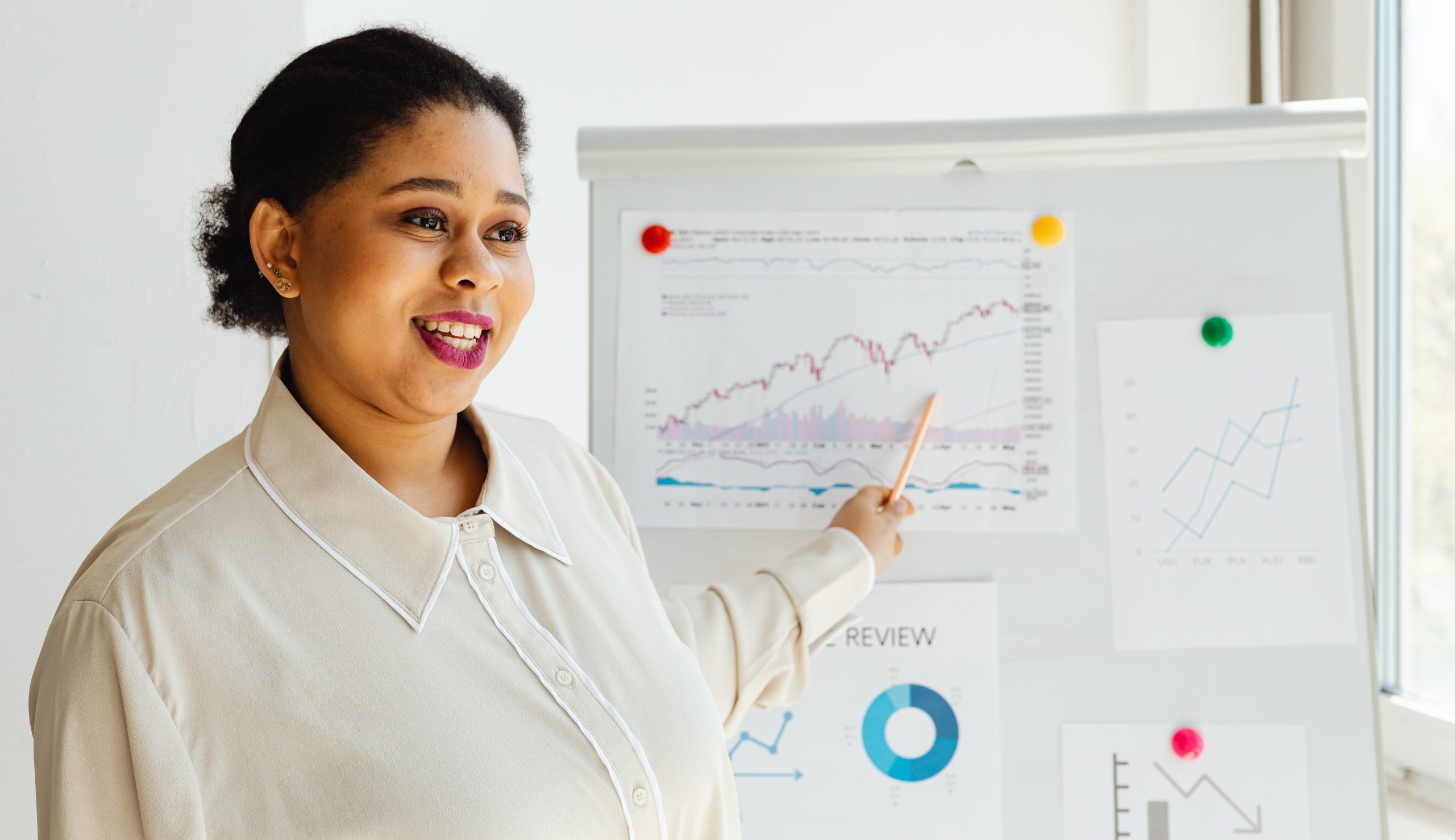 A woman pointing a graph posted on a white board