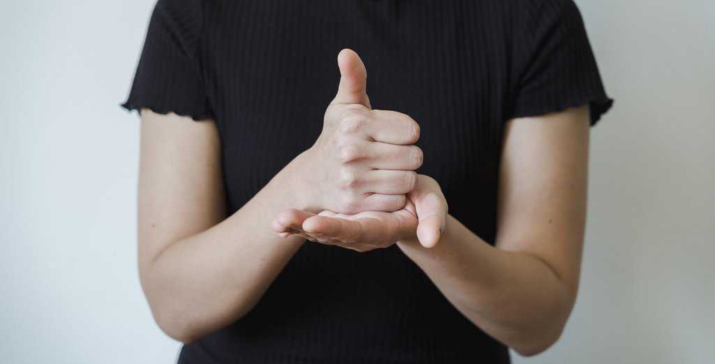 Hands of a woman making hand gesture of thumbs up