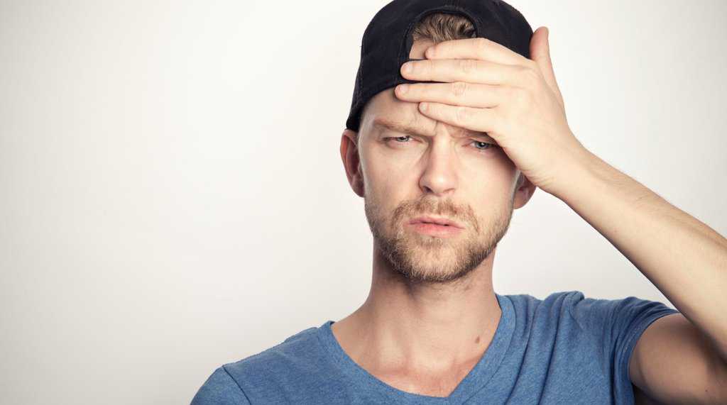 man in blue crew neck shirt covering his face