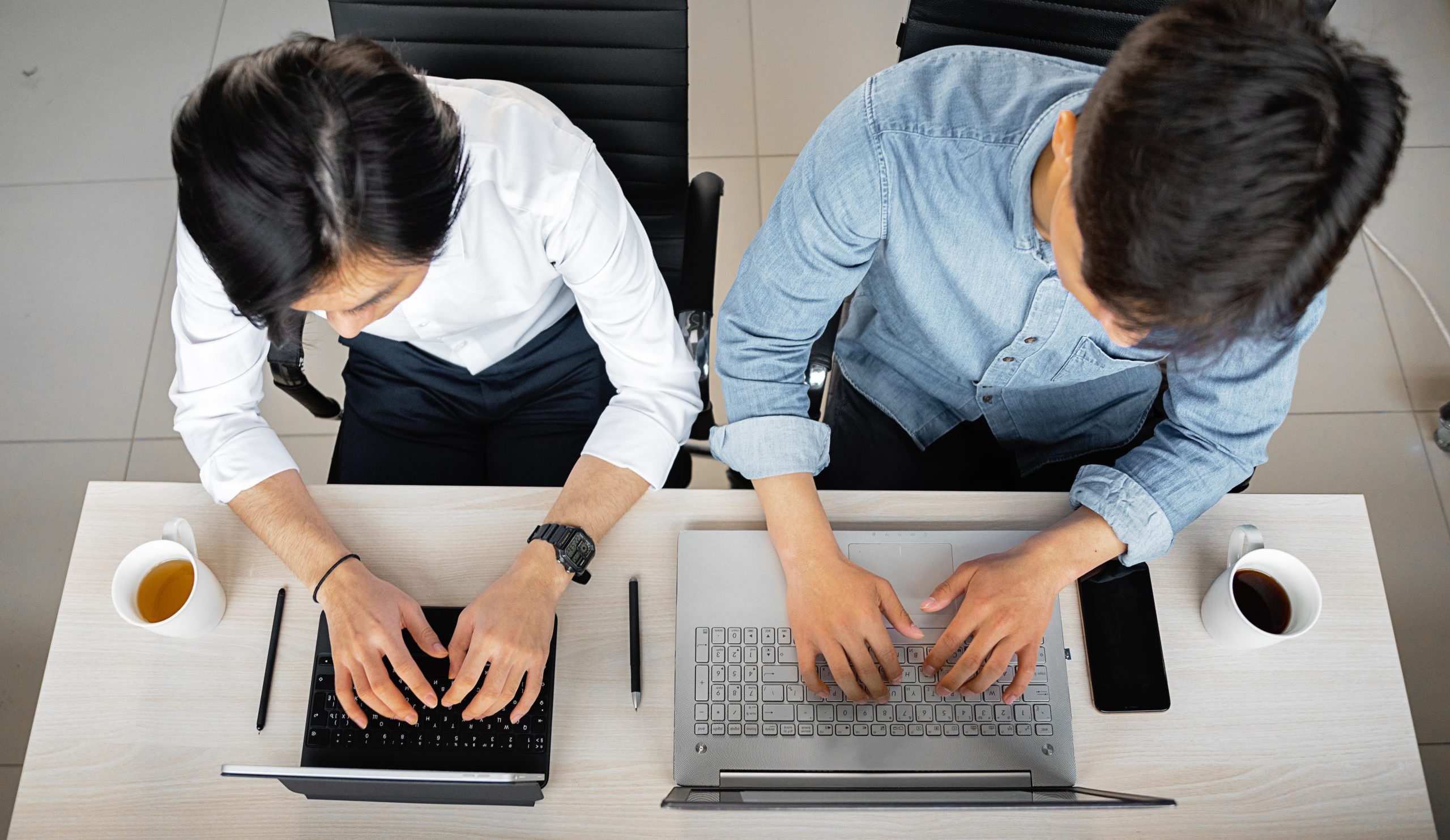 Overhead shot of coworkers typing on electronic devices