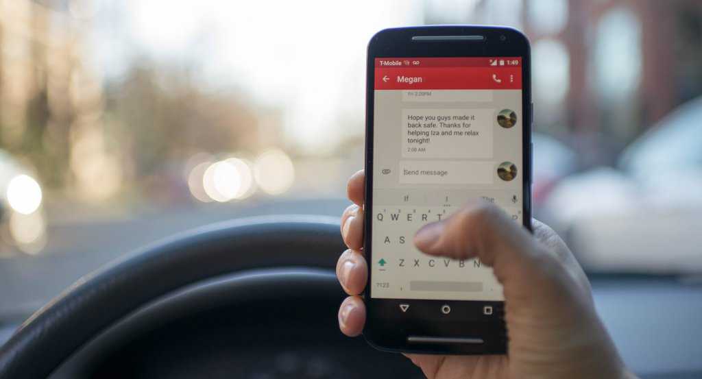 Person sitting inside car with black android smartphone turned on