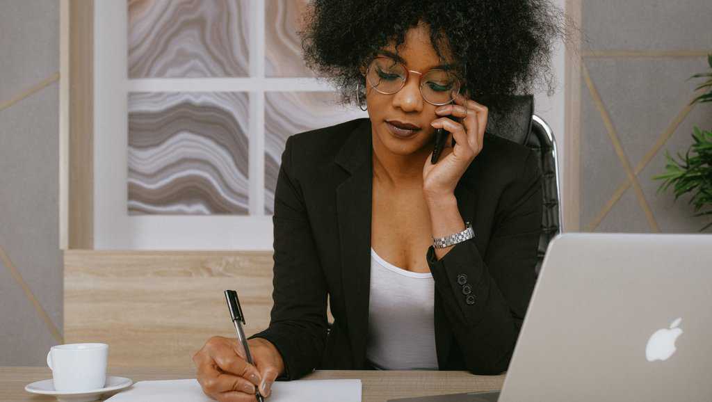 Woman in black blazer holding smartphone