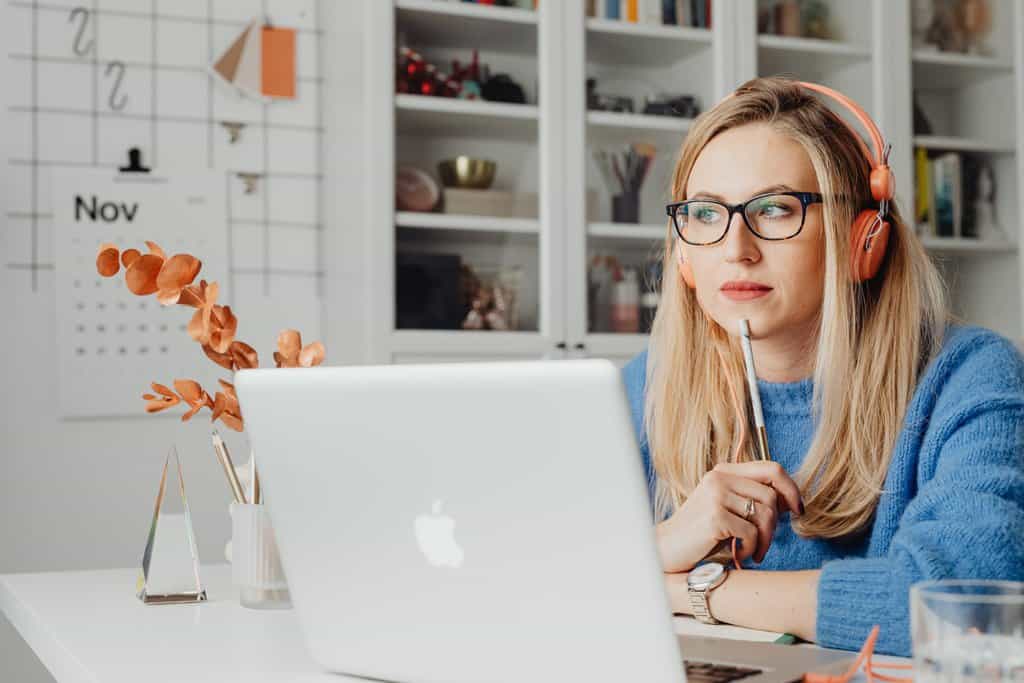 Woman using laptop and wearing headphones