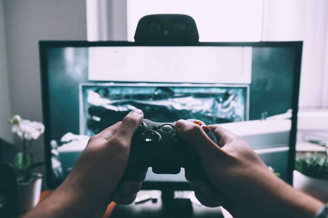 person holding game controller in-front of television pubg, custom skins, game modification