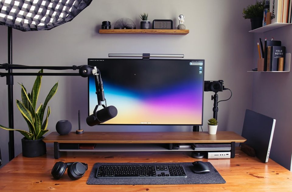 a desk with a monitor, keyboard and headphones designer workspace desktop large monitor design software interface
