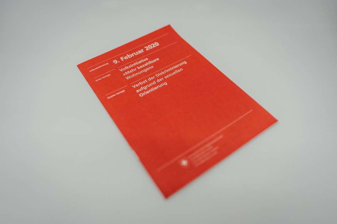 red book on white table business cards, design software, adobe express