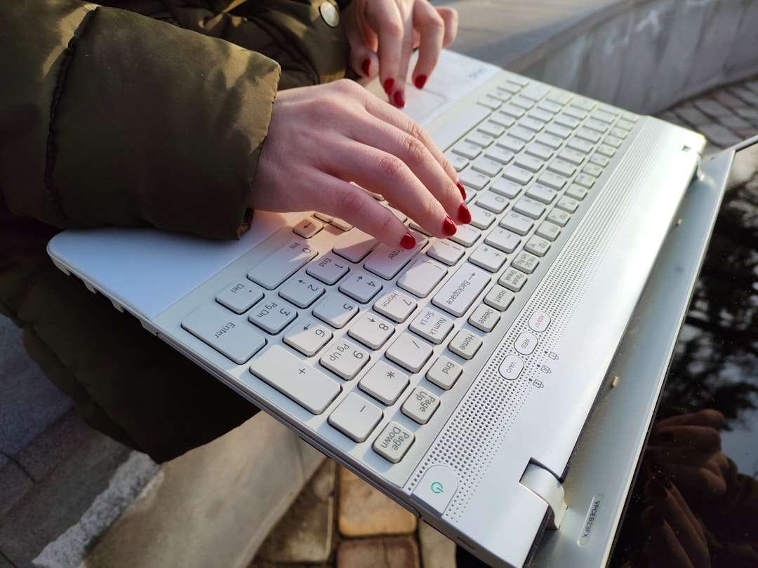 a woman is typing on a laptop outside vpn laptop security remote work worker
