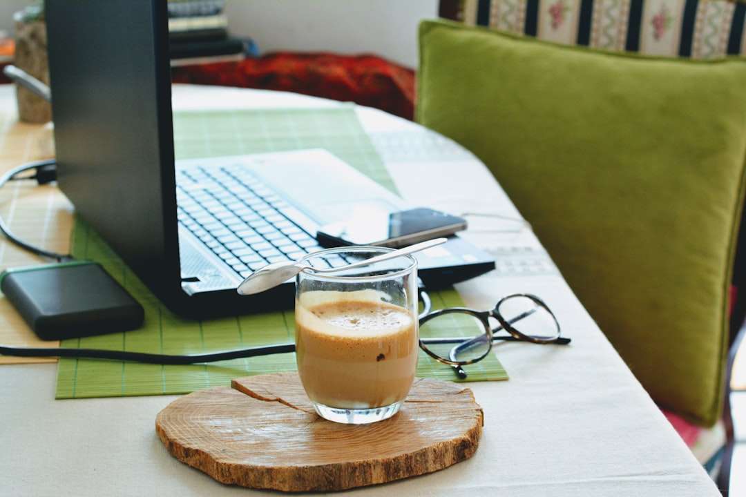 half full half empty drink in clear drinking glass on table beside laptop laptop blogger coffee wordpress