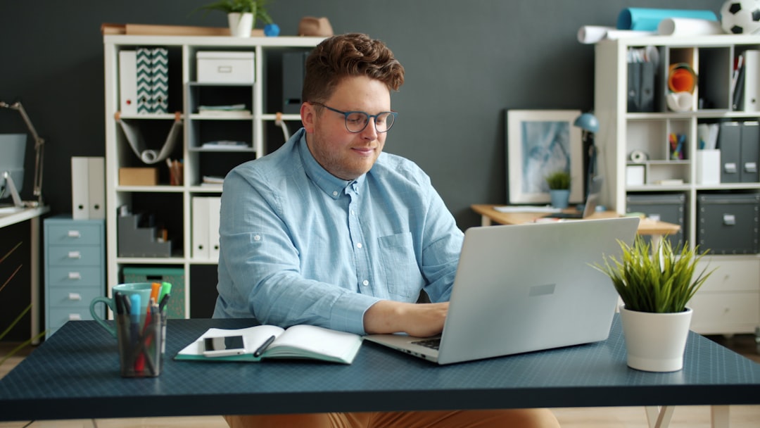 Man working on laptop at desk in office. small business accounting dashboard, laptop screen finance charts, entrepreneur working desk