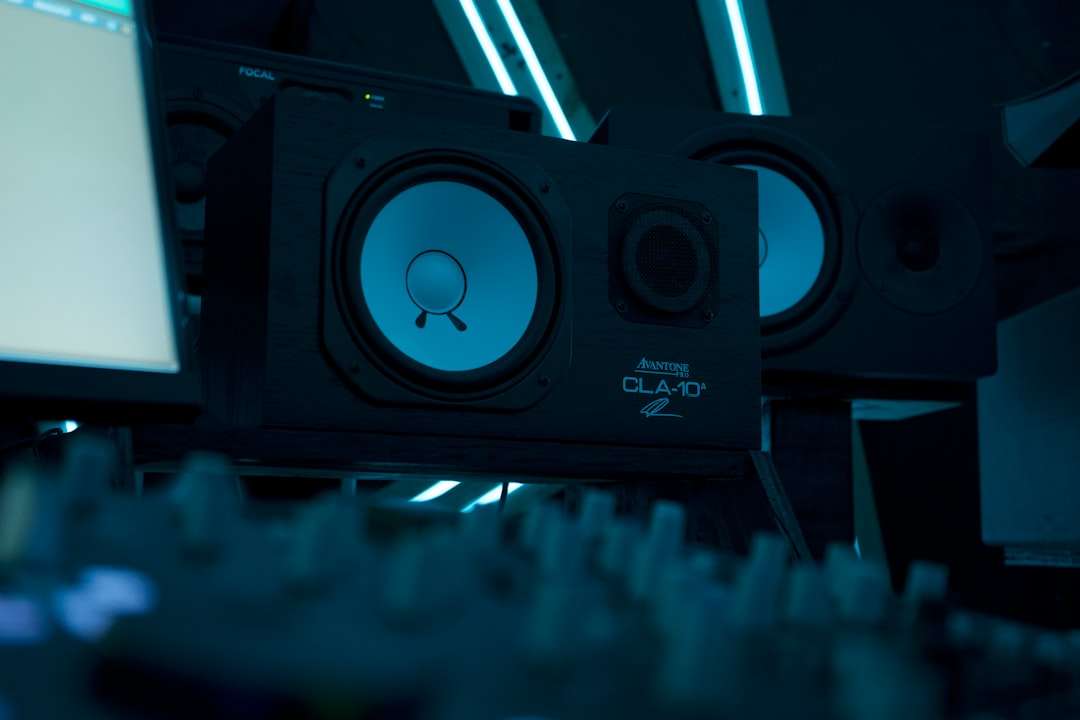 a close up of a speaker with a monitor in the background qsc speaker,dj setup,live music