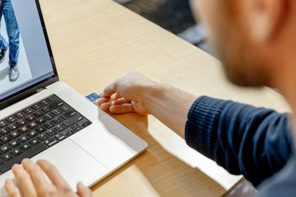 A man sitting in front of a laptop computer frictionless checkout, online customer dashboard, fast b2b reorder