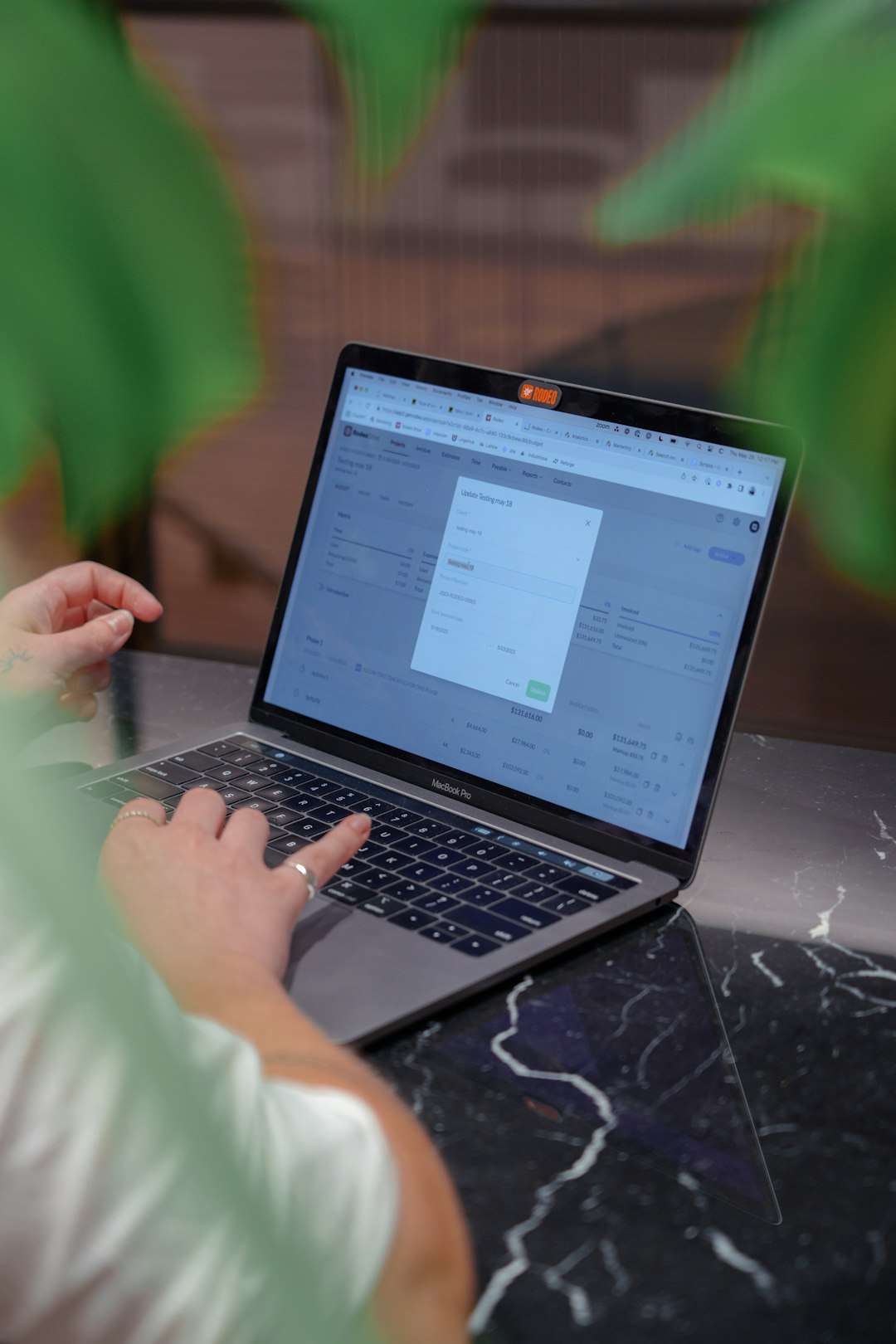 a woman sitting at a table using a laptop computer teacher laptop course creation