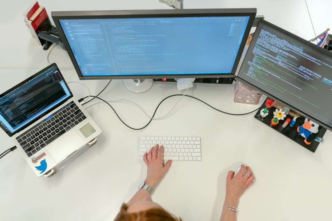 person using macbook pro on white table developer office ai coding assistant laptop