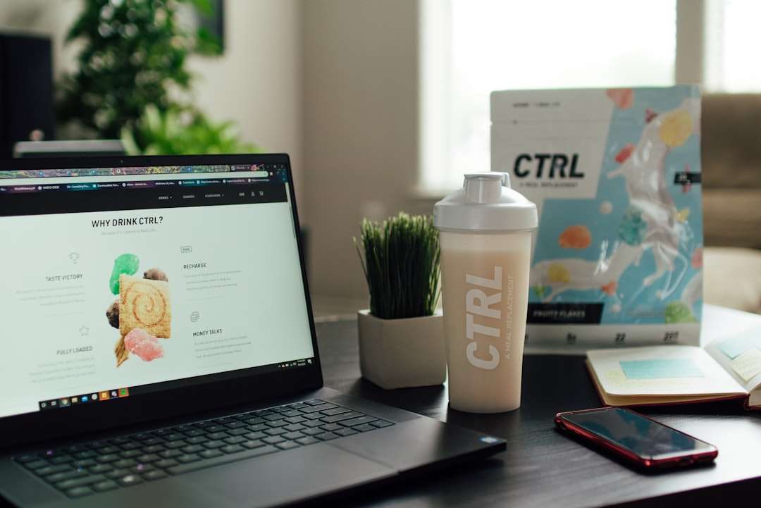 macbook pro beside white ceramic mug on brown wooden table fitness branding, modern logo design, startup kit