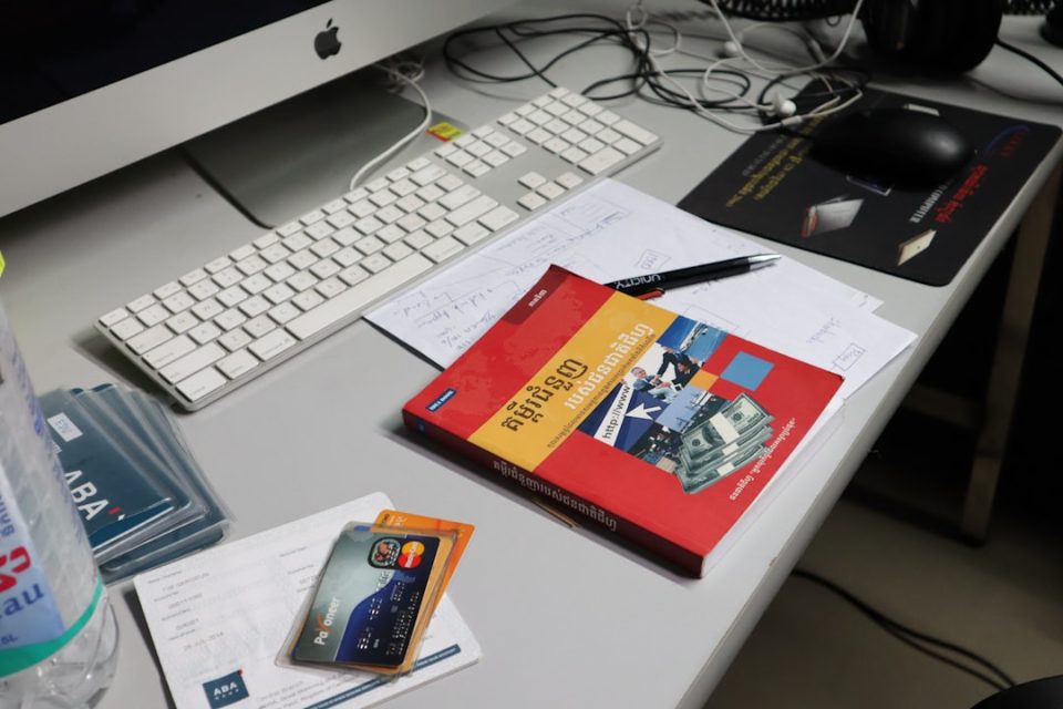 A messy desk with computer and books. business card design template screen laptop modern workspace