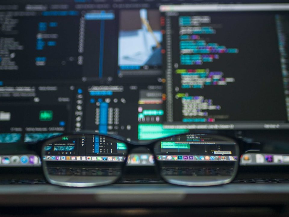 closeup photo of eyeglasses security operations center dashboard, data visualization screens, cybersecurity monitoring team