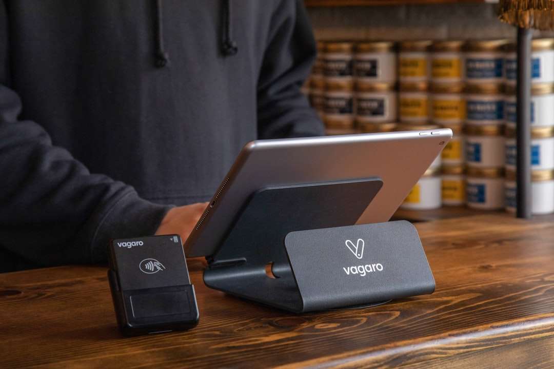 a person standing at a table with a laptop and a charger portable wifi hotspot device, smartphone tethering screen, laptop connected to wifi