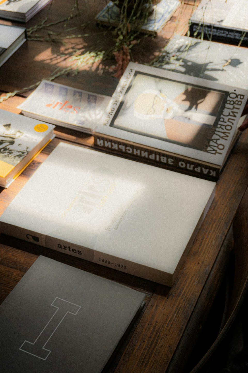 A table topped with lots of books on top of a wooden table hardcover memory book family photo album on table soft natural light