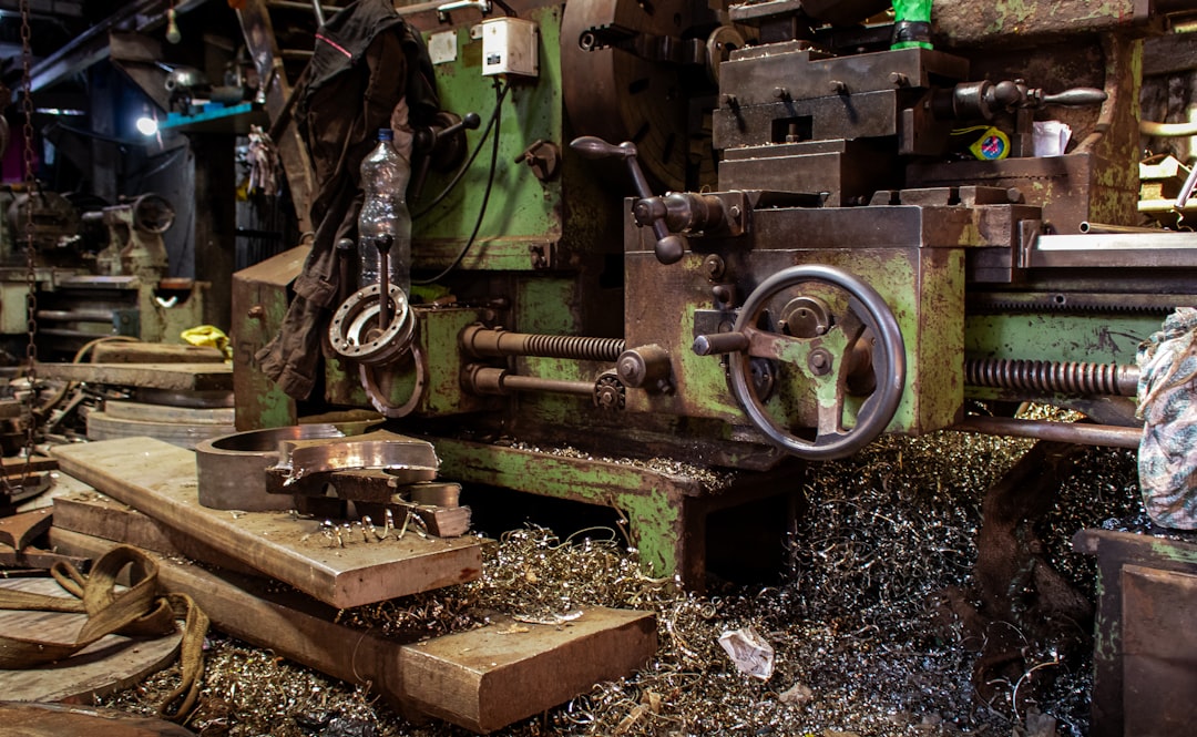 Old metal lathe machine covered in debris precision mold, resin casting process, industrial manufacturing facility