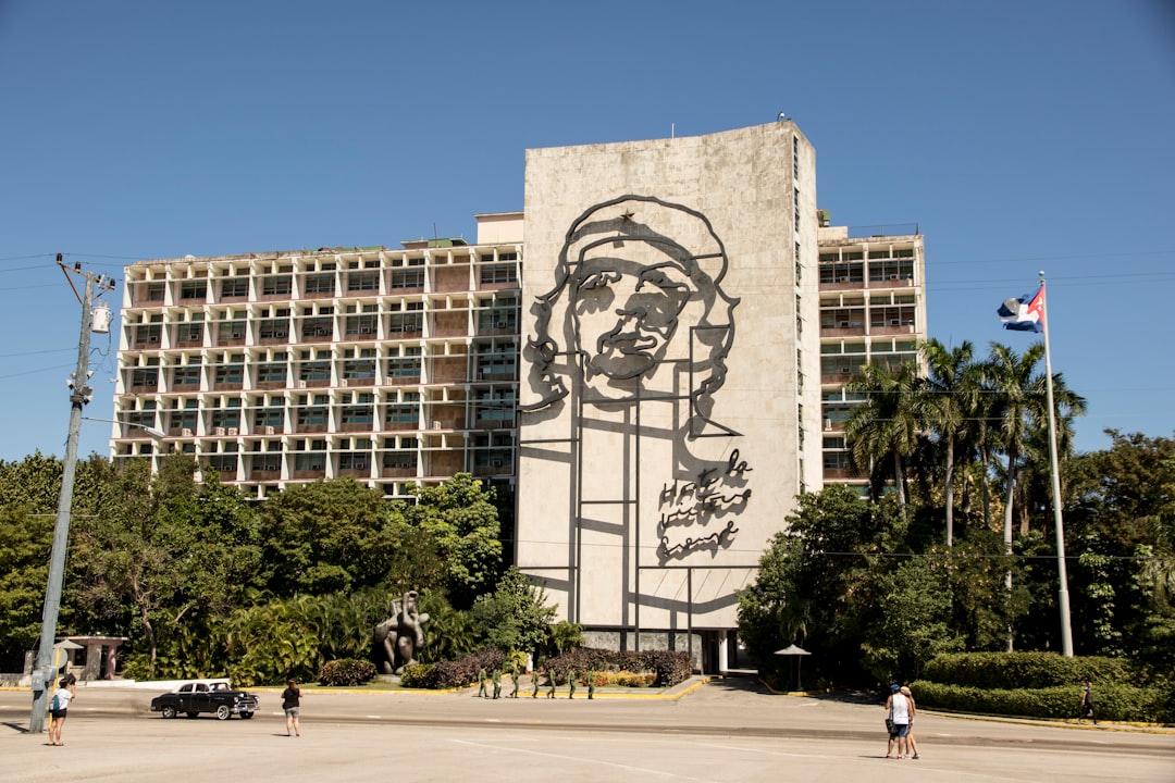 people walking near brown concrete building during daytime Fidel Castro speech Havana, Cuban revolution 1959 crowd, revolutionary leader uniform